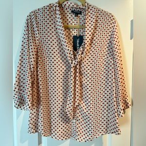 Patterned elbow length blouse with a button at the elbow.